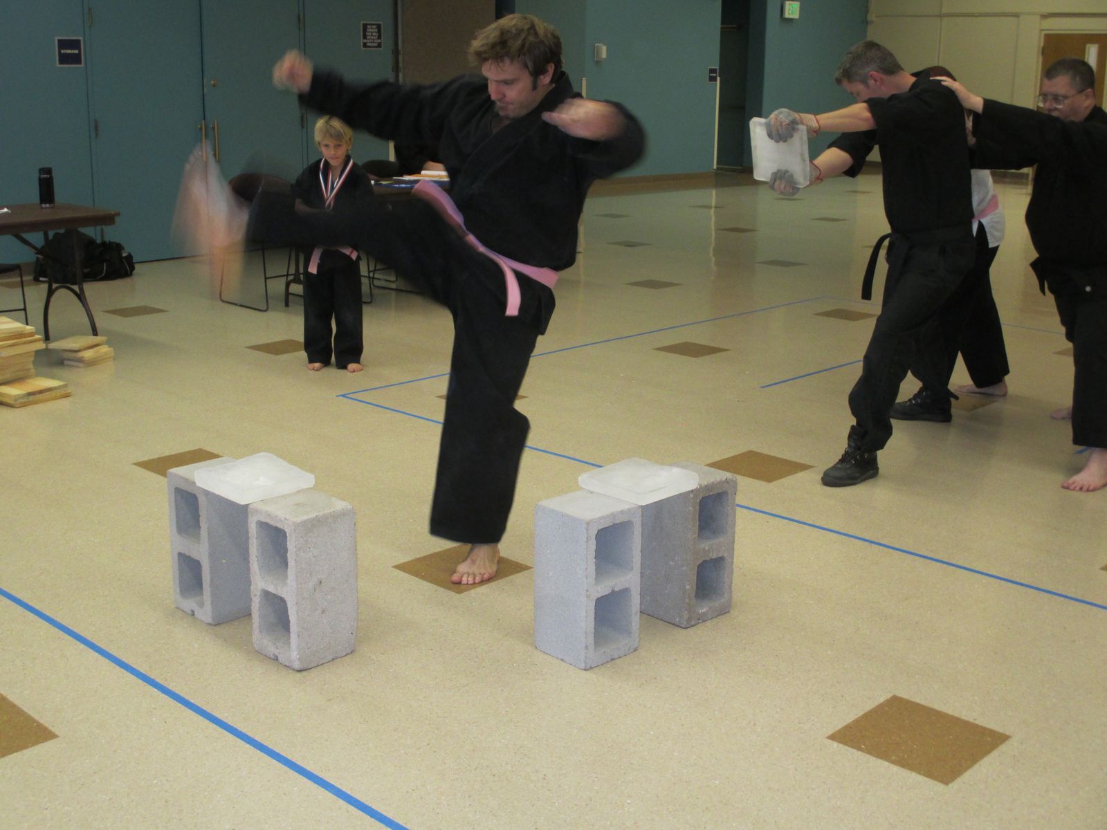 An adult student breaking concrete blocks with a kick