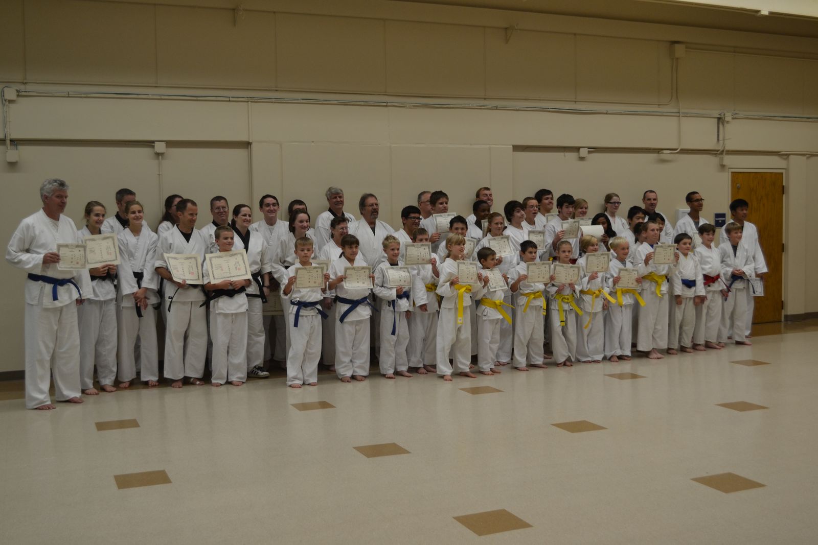 Students of every rank holding their new belt certificates