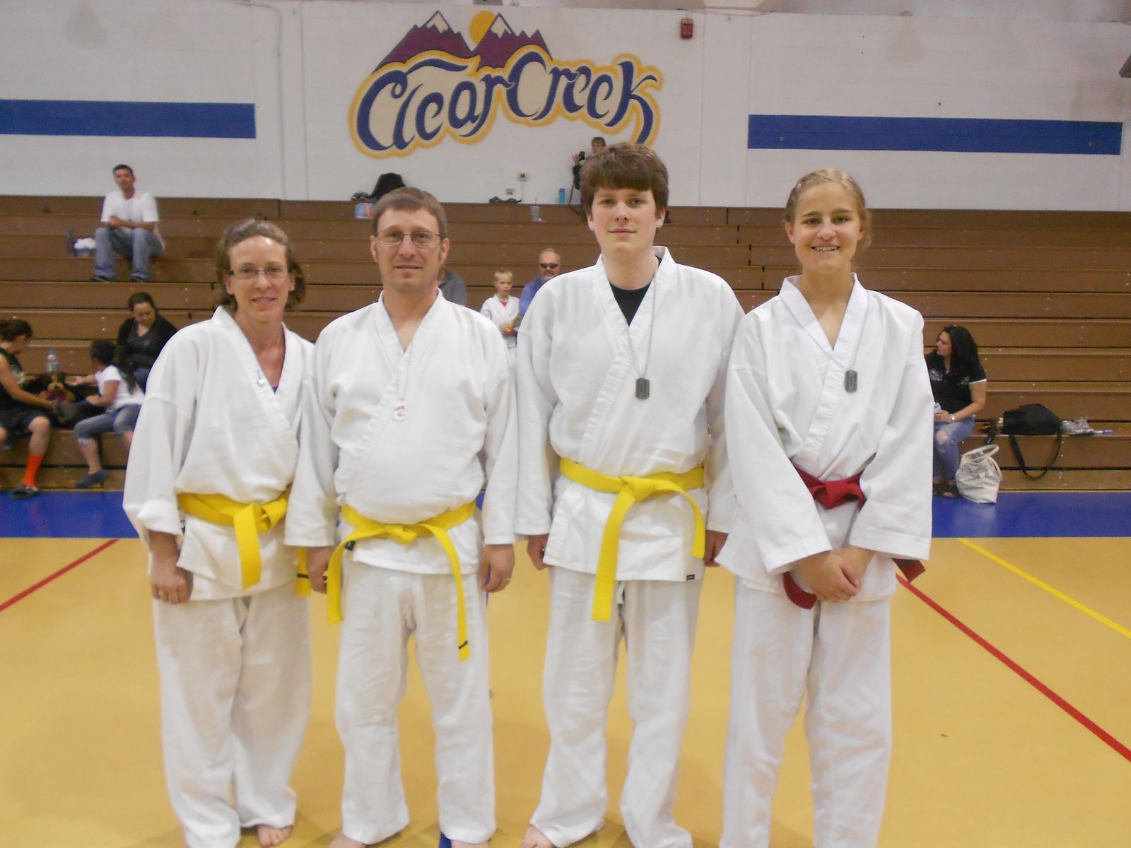 Parents and teens with yellow belts standing together