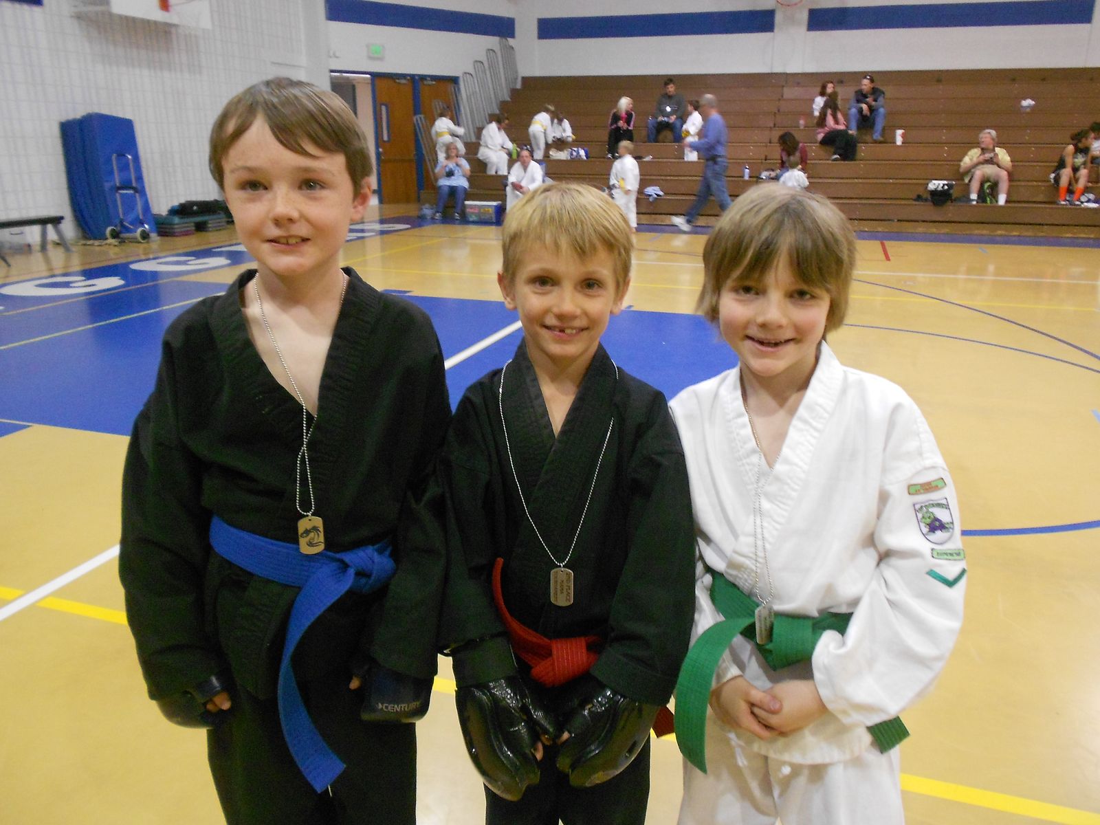 Three young students smiling in their uniforms
